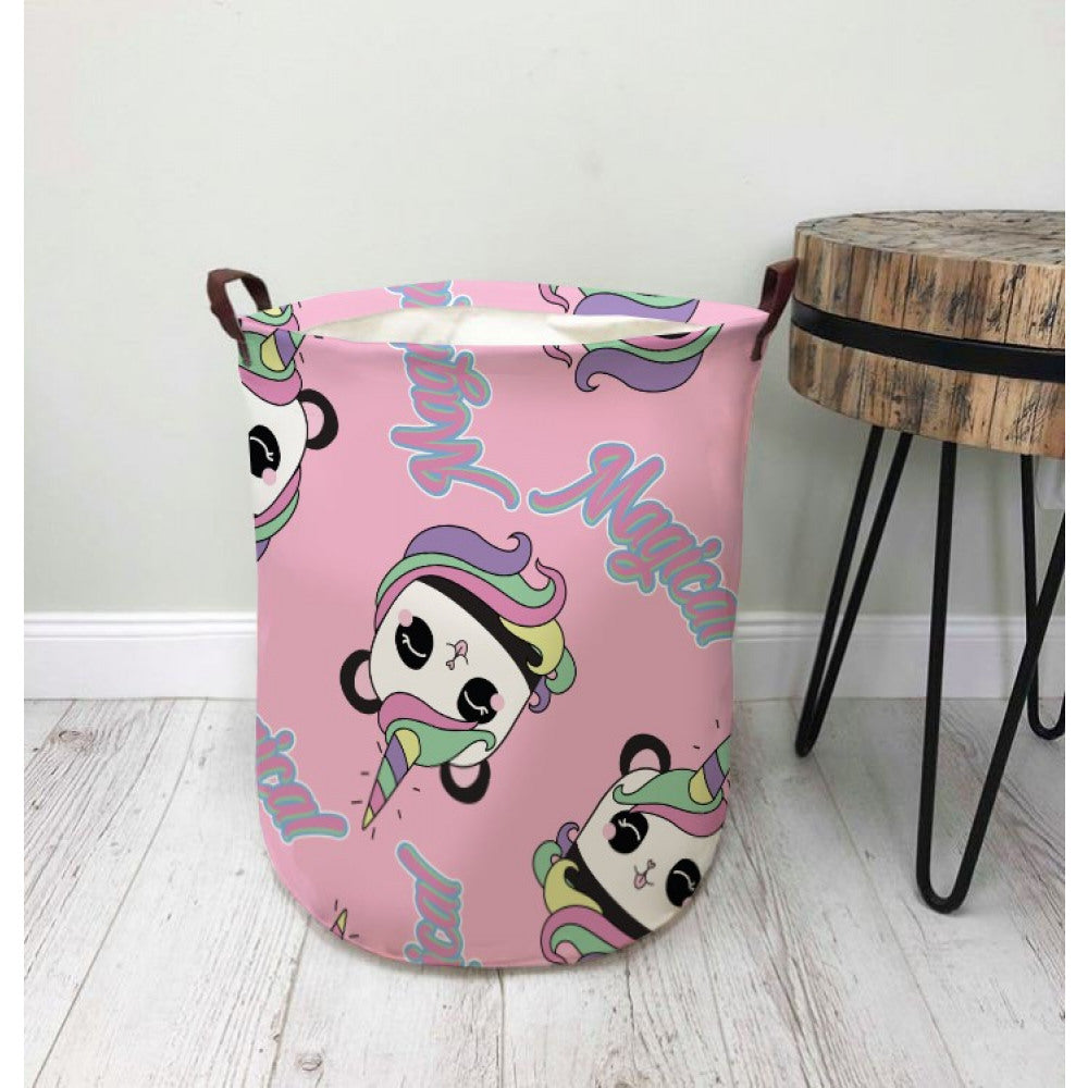 Rosa Aufbewahrungskorb mit buntem Einhorn-Motiv und seitlichen Tragegriffen auf hellem Boden.