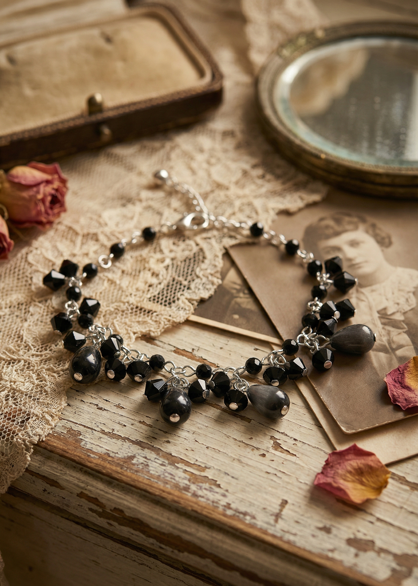 Filigranes Gothic Perlen Armkettchen mit schwarzen Perlen und tropfenförmigen Anhängern auf einer Vintage-Holzoberfläche mit Spitze dekoriert.