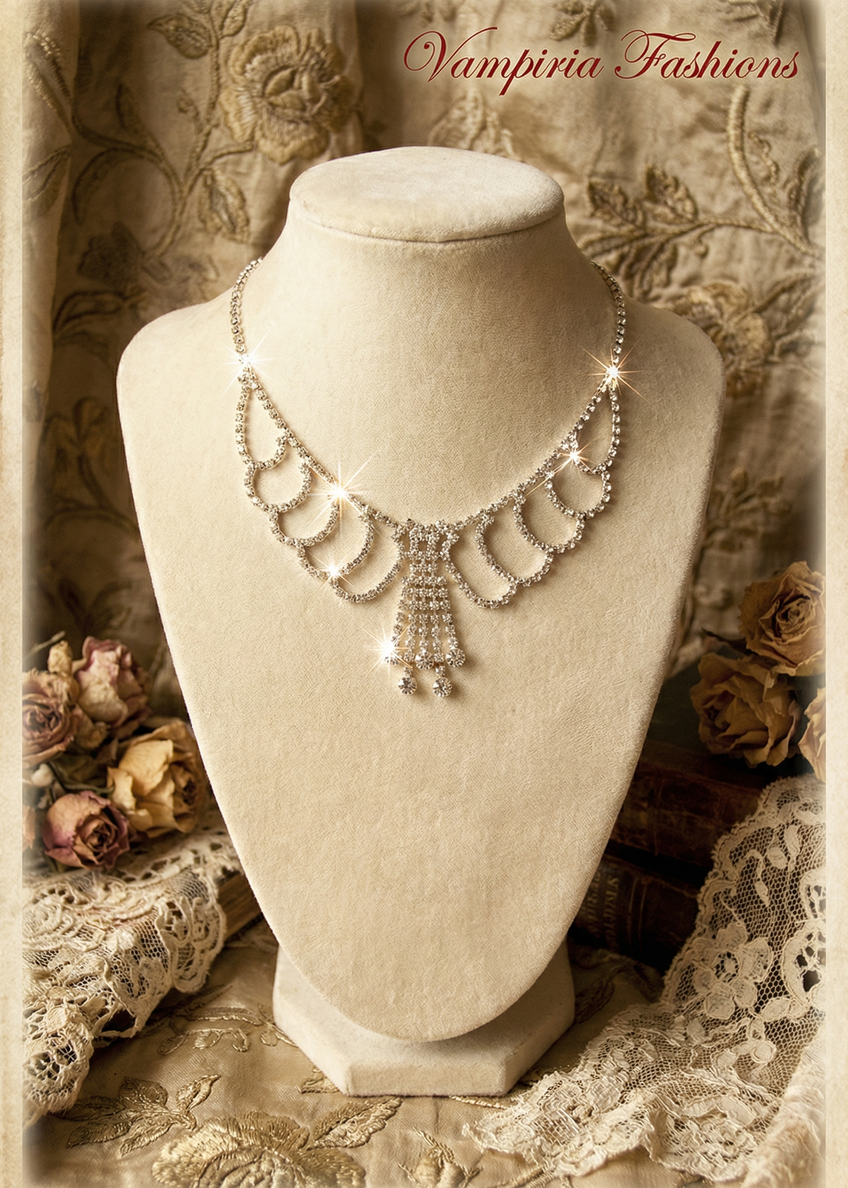 Böhmisches Strass-Collier auf Schmuckbüste vor Vintage-Dekoration mit Spitze und Rosen