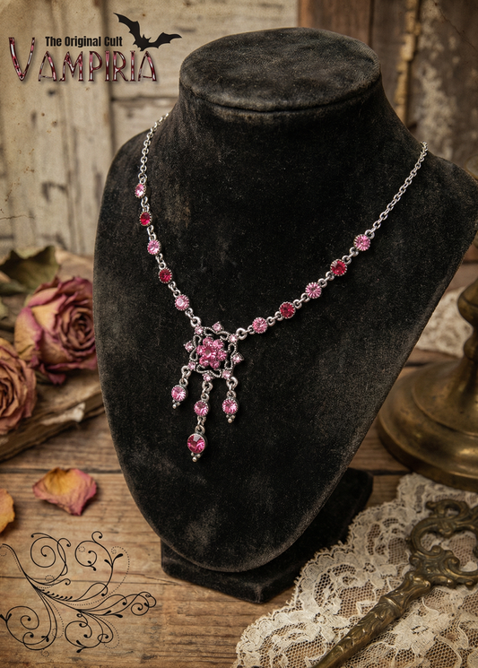 Rosa Kristall-Collier auf schwarzer Samtbüste mit filigranem Mittelornament und Anhängern, Vintage Hintergrund.