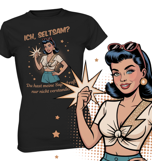Schwarzes T-Shirt mit Motiv: Retro-Girl mit Sonnenbrille im 50s-Stil, mit Text „Ich, seltsam? Du hast nur meine Superkraft nicht verstanden!“. Rechts vorne im Bild eine vergrößerte Darstellung der Frau im Comic-Stil.