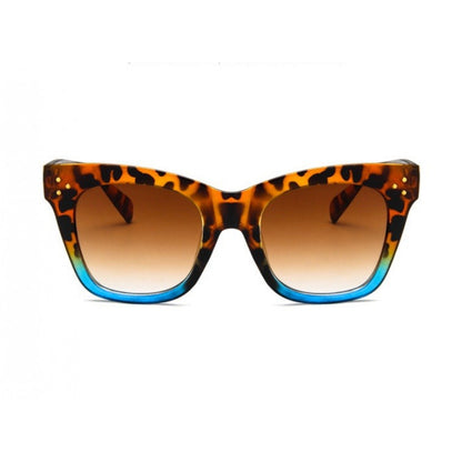 Sonnenbrille mit Leopardenmuster, braun getönten Gläsern und eckigem Rahmen auf hellem Hintergrund.