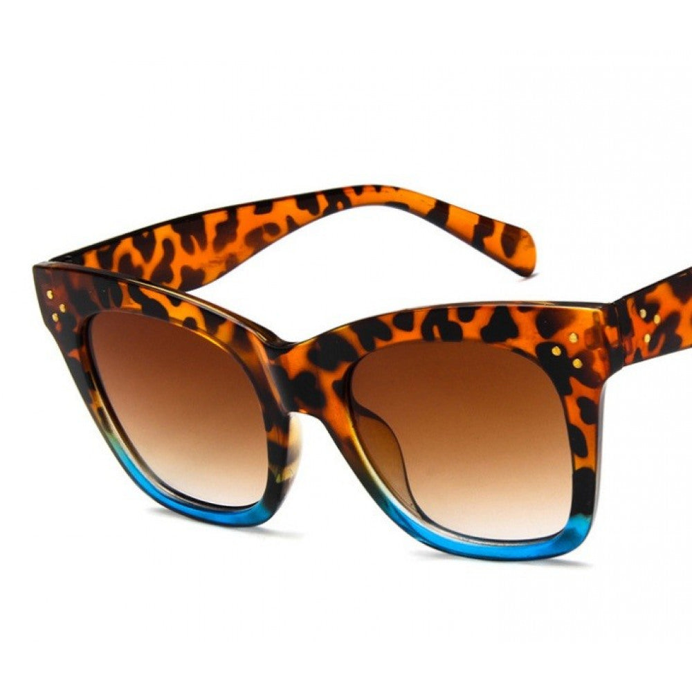 Sonnenbrille mit Leopardenmuster, braun getönten Gläsern und eckigem Rahmen auf hellem Hintergrund.