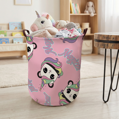 Rosa Aufbewahrungskorb mit buntem Einhorn-Motiv und seitlichen Tragegriffen auf hellem Boden.