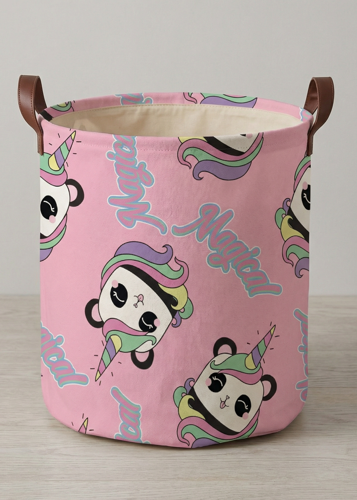 Rosa Aufbewahrungskorb mit buntem Einhorn-Motiv und seitlichen Tragegriffen auf hellem Boden.