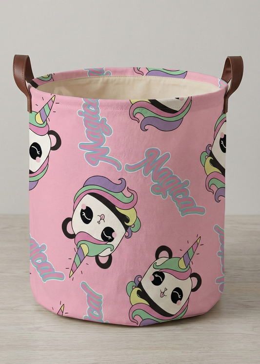 Rosa Aufbewahrungskorb mit buntem Einhorn-Motiv und seitlichen Tragegriffen auf hellem Boden.