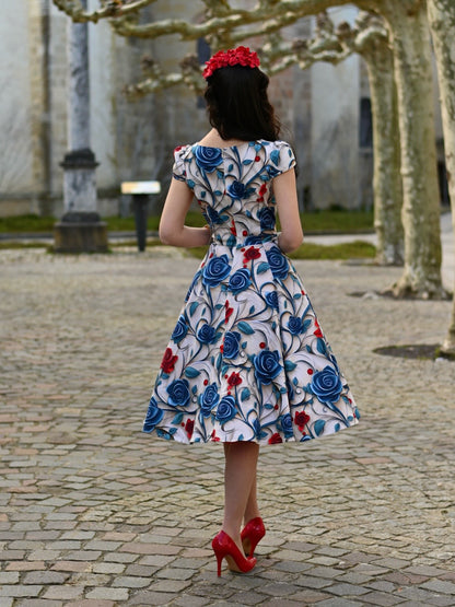 Eine Frau trägt das Elowen Floral Swing Dress, Ganzkörperansicht im Stehen, Ansicht von hinten.
