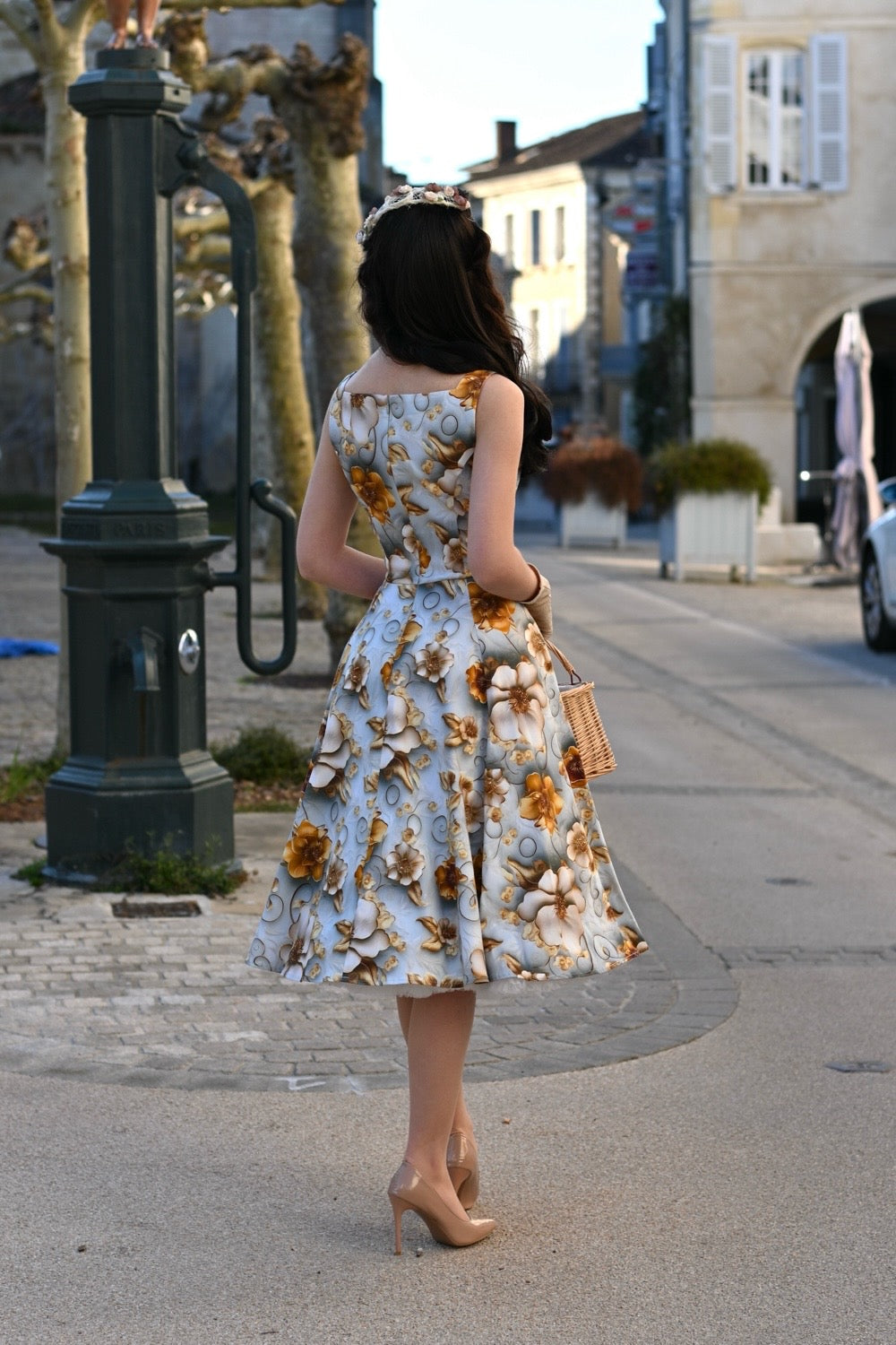 Eine Frau trägt das Mavis Floral Swing Dress, Ganzkörperansicht im Stehen, Ansicht von hinten