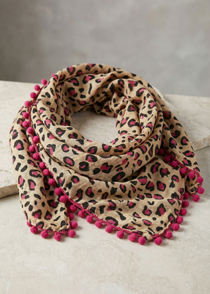 Baumwollschal mit Leopardenmuster und pinken Pommel-Bommeln auf hellem Hintergrund.