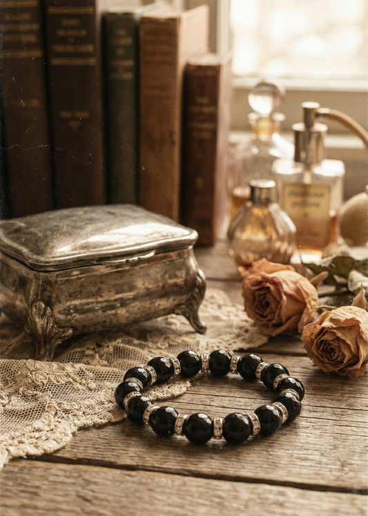 Gothic Armband mit schwarzen Perlen und Metall-Elementen auf Vintage-Holzuntergrund.