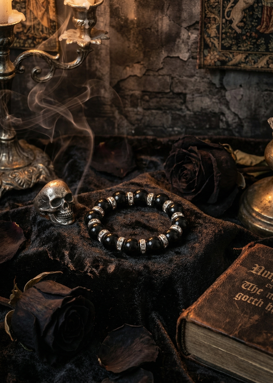 Schwarzes Gothic-Armband mit Perlen auf dunklem Samt neben Kerzen und Dekoration.