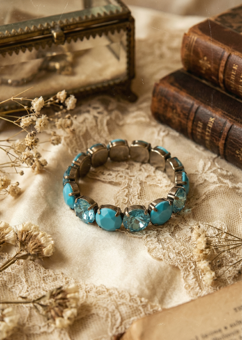 Türkisfarbenes Armband mit facettierten Steinen auf rustikalem Holztisch im Vintage-Setting.