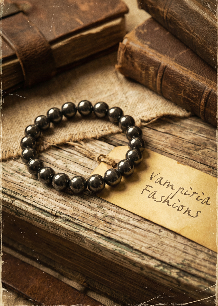 Dunkles Hämatit-Perlenarmband auf Holzoberfläche im Vintage-Styling mit Texturhintergrund.