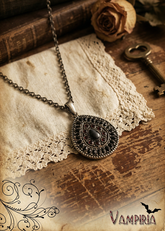 Gothic Halskette mit tropfenförmigem Anhänger und dunklem Cat-Eye-Stein auf Holzuntergrund