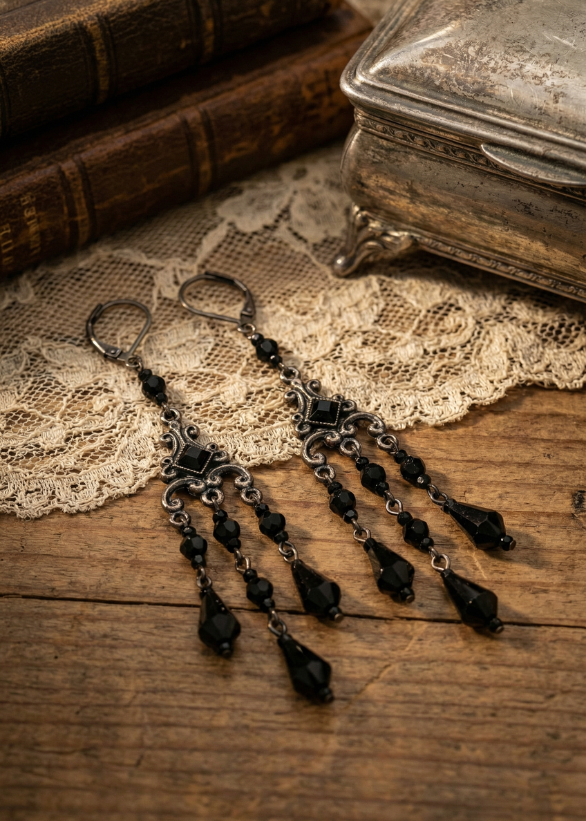 Lange Vintage-Ohrringe mit schwarzen Perlen und filigranem Ornament-Design auf Schmuckhalter.