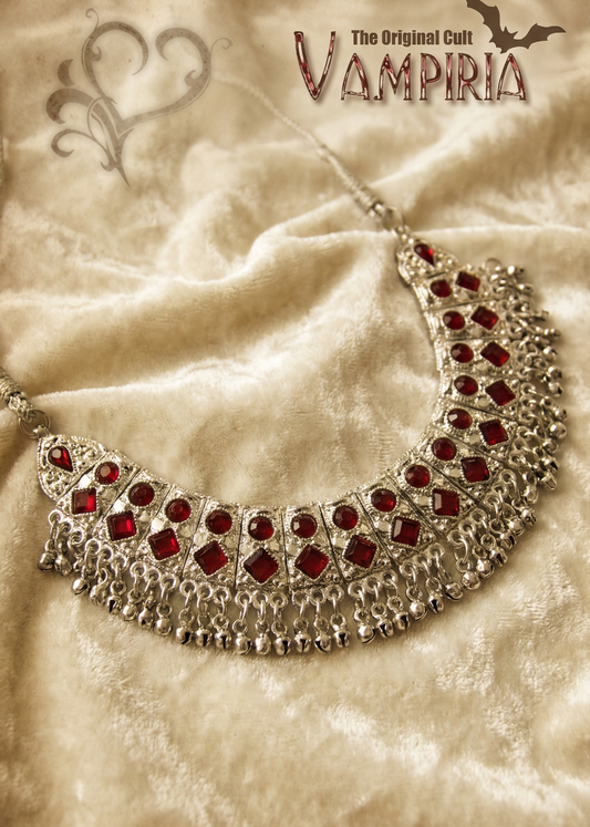 Bollywood Boho Style Collier mit roten Schmucksteinen auf hellem Stoffhintergrund.