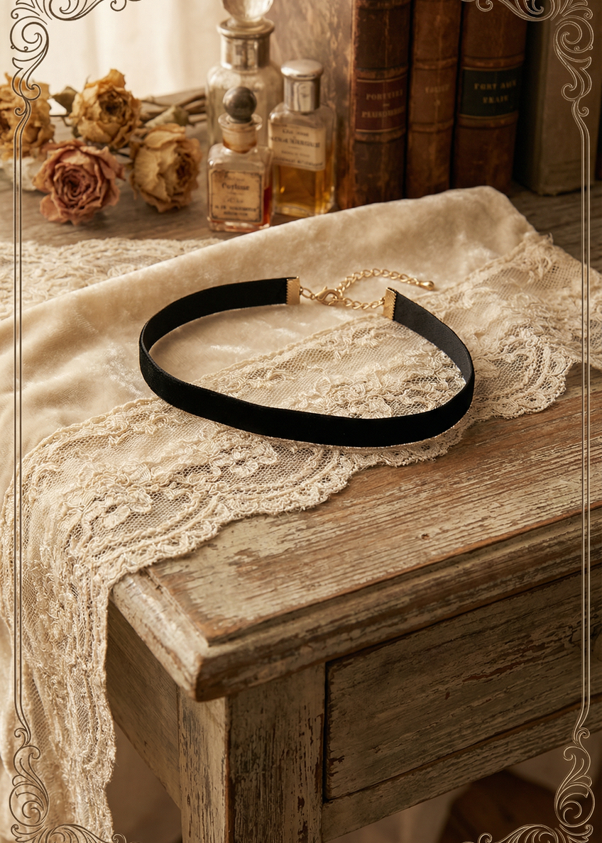 Schwarzes Samt-Halsband mit goldfarbenem Verlängerungskettchen auf vintage Tisch dekoriert.