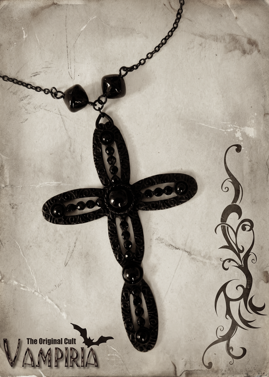 Schwarze Halskette mit großem verziertem Kreuzanhänger und schwarzen glänzenden Steinelementen auf hellem Hintergrund im Vintage-Stil.