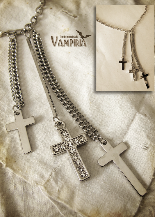 Nahaufnahme der Triple-Cross-Halskette auf hellem Stoff mit Einblendung des gesamten Schmucks im kleinen Bildausschnitt.