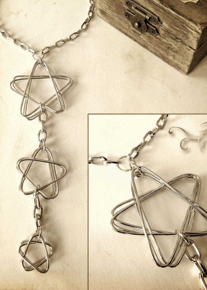 Detailaufnahme des Colliers mit drei offenen Sternformen aus Draht, Nahansicht auf hellem Hintergrund.