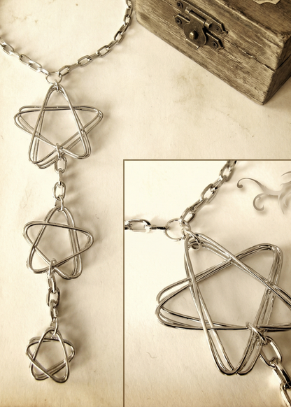 Detailaufnahme des Colliers mit drei offenen Sternformen aus Draht, Nahansicht auf hellem Hintergrund.