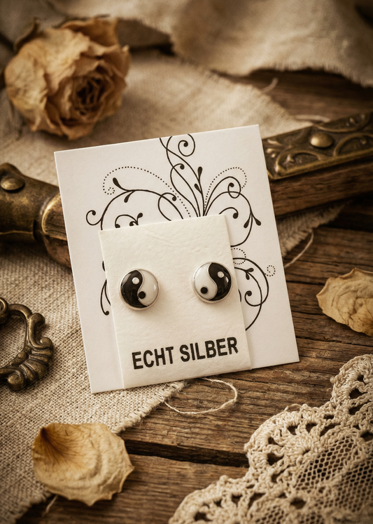 Yin-Yang Ohrstecker aus Echt Silber auf Schmuckkarte mit dekorativem Hintergrund.