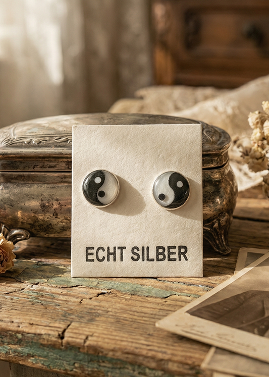 Yin-Yang Ohrstecker aus Echt Silber auf Schmuckkarte vor Vintage-Hintergrund.