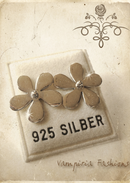 Zwei silberfarbene Blumen-Ohrstecker auf Schmuckkarte mit Aufdruck „925 Silber“, helle Vintage-Darstellung mit dekorativem Hintergrund.