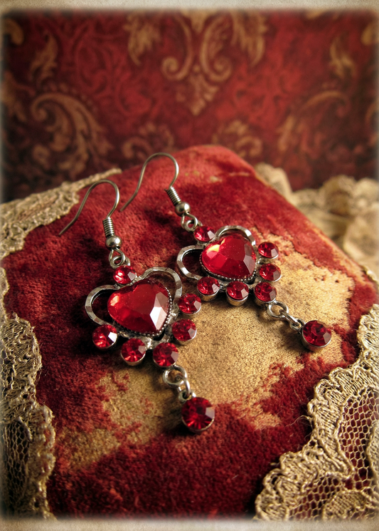 Rote Herz-Ohrringe mit roten Kristallsteinen auf rotem Samtkissen mit Spitze im Vintage-Stil.