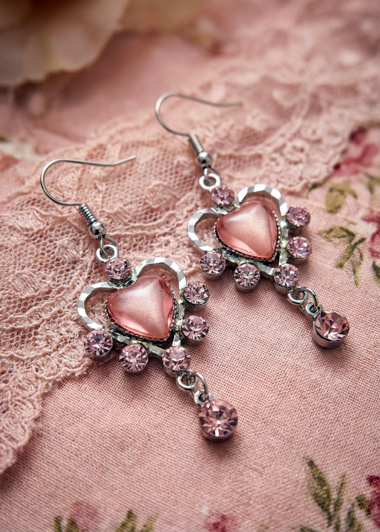 Rosa Vintage Herz-Ohrringe mit rosafarbenen Strasssteinen und kleinem Anhänger auf rosa Stoffspitze