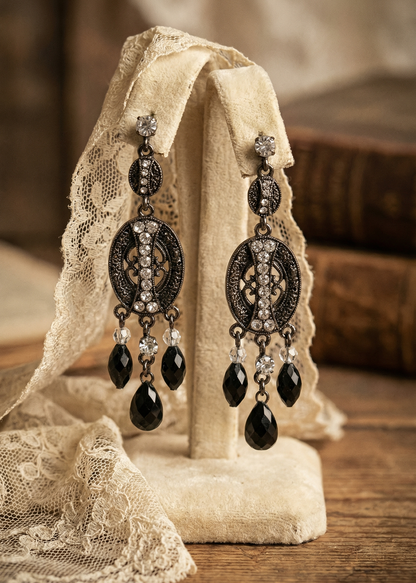 Vintage Gothic Ohrhänger mit schwarzen Tropfen und Ornamenten auf hellem Schmuckständer.