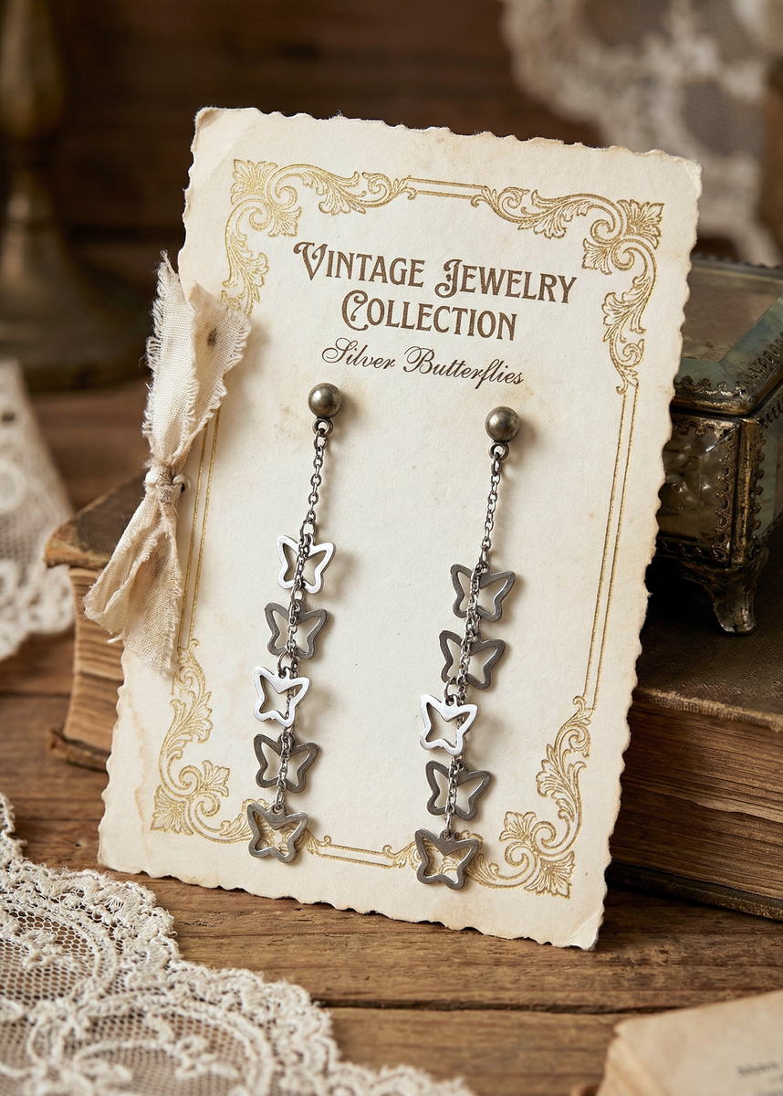 Lange silberfarbene Vintage-Ohrringe mit mehreren offenen Schmetterlings-Anhängern auf einer Schmuckkarte mit Aufschrift „Vintage Jewelry Collection“.
