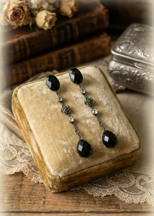 Gothic Ohrstecker mit schwarzen Tropfenhängern und floralen Details auf vintage Samtbox präsentiert.